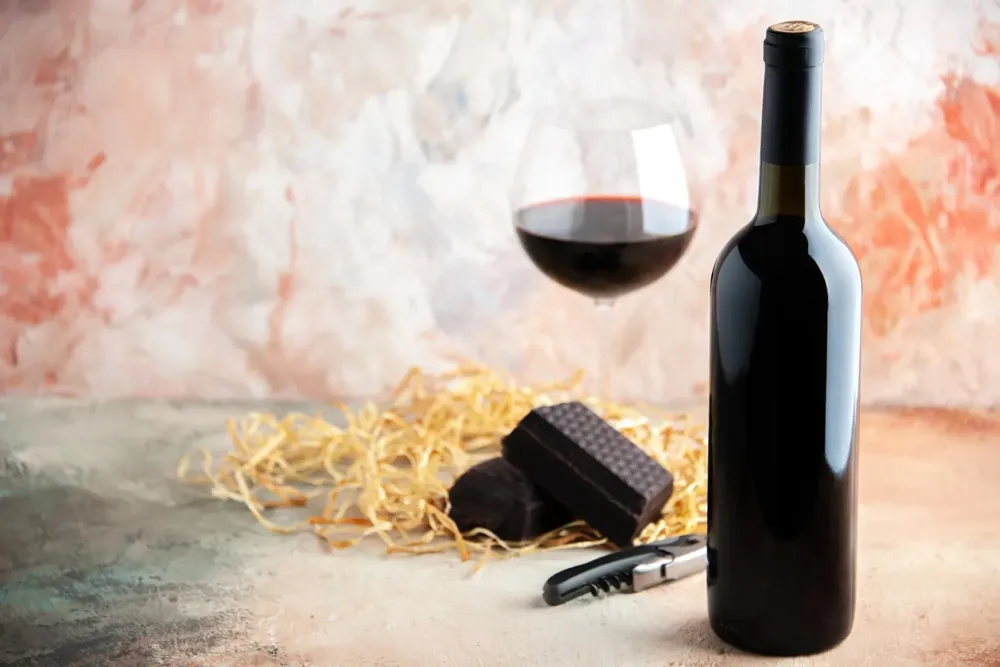 vista-frontal-copa-vino-botella-chocolate. Foto Freepik